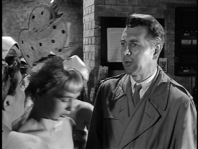 Figure 26: Time Without Pity, 1957. Amongst the backstage dancehall bustle a trench coated David Graham (Michael Redgrave) seeks information. The showgirls in their chicken hats contrast Graham’s seriousness and desperation.